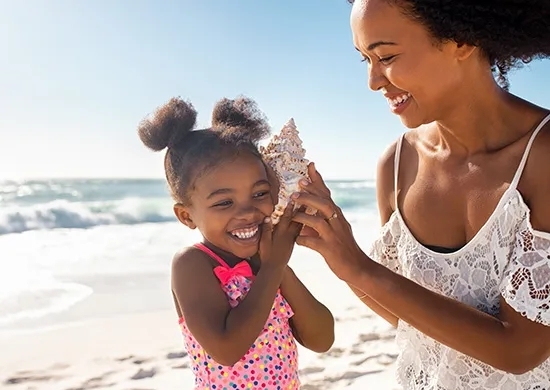 Little girl with seashell and mom