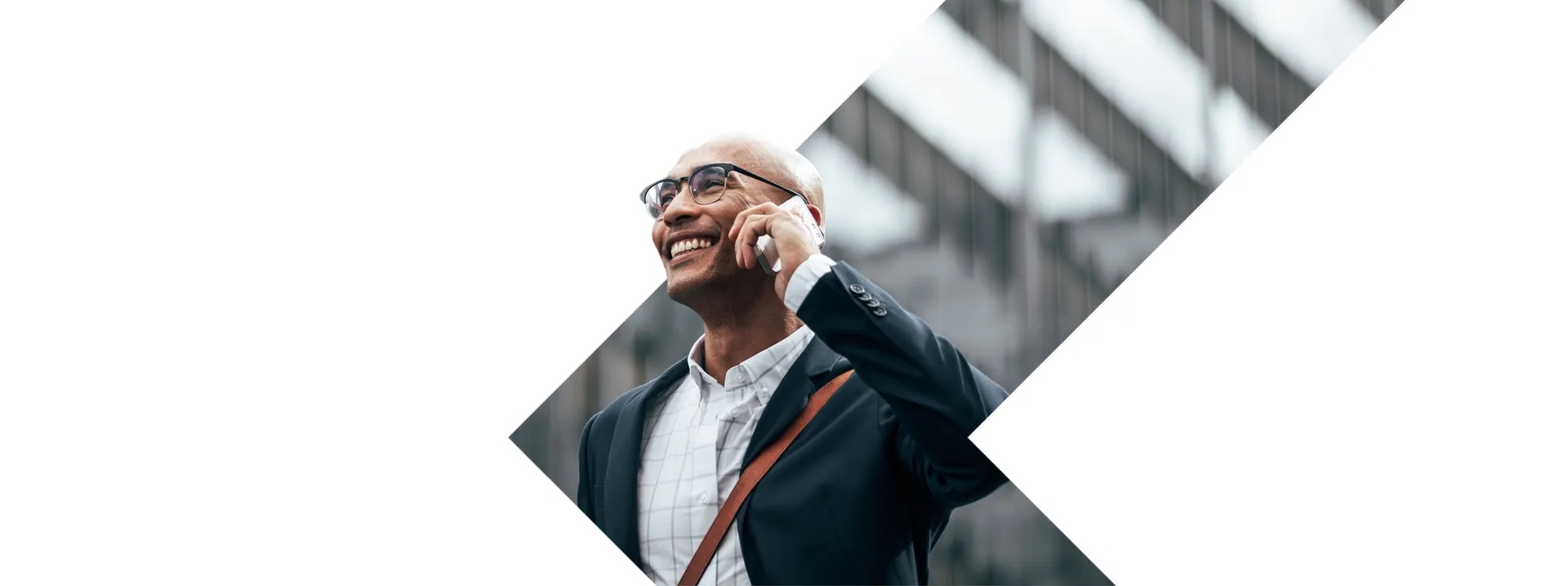 A man standing in front of building talking on the phone