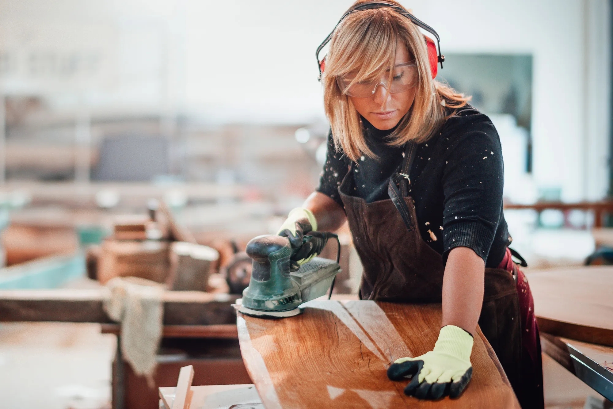 A woman completing a touchless transaction with a terminal, working within a bakery.