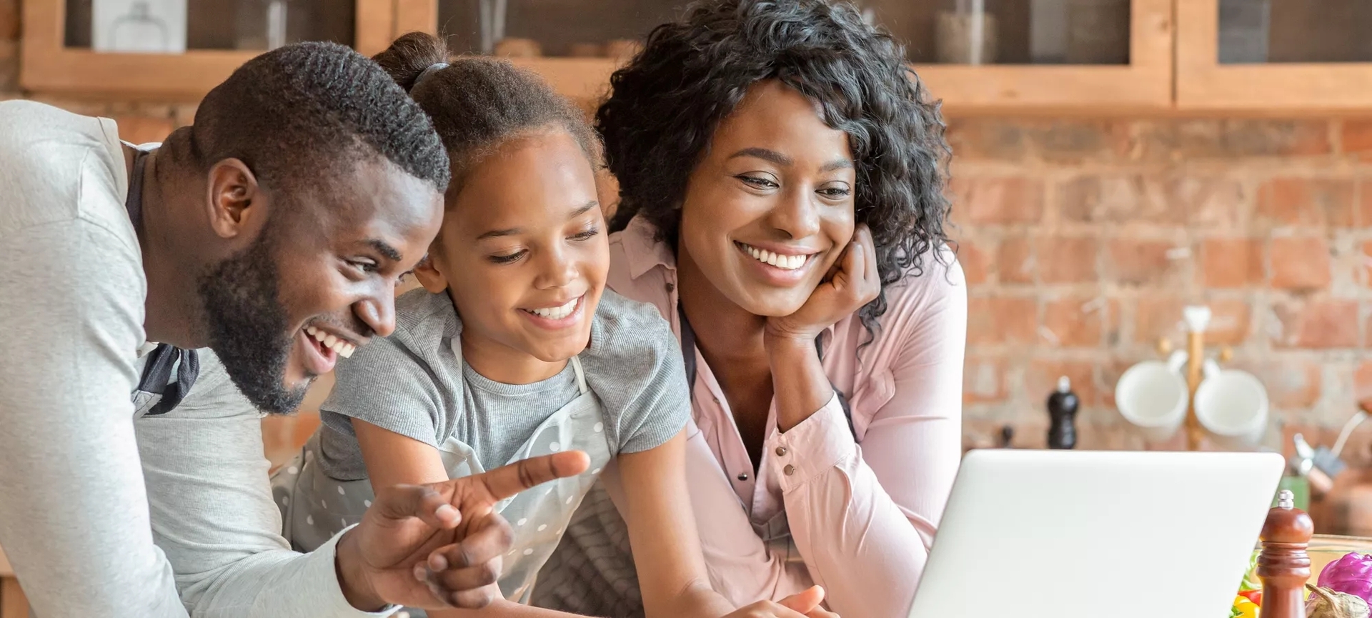 Family of three looking at a laptop.